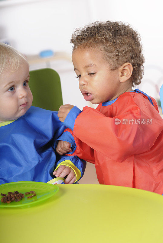 混血婴儿/幼童与他的同伴在用餐时间互动